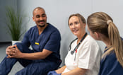 Helsefagarbeidere som sitter sammen i gang på sykehjem. Foto.