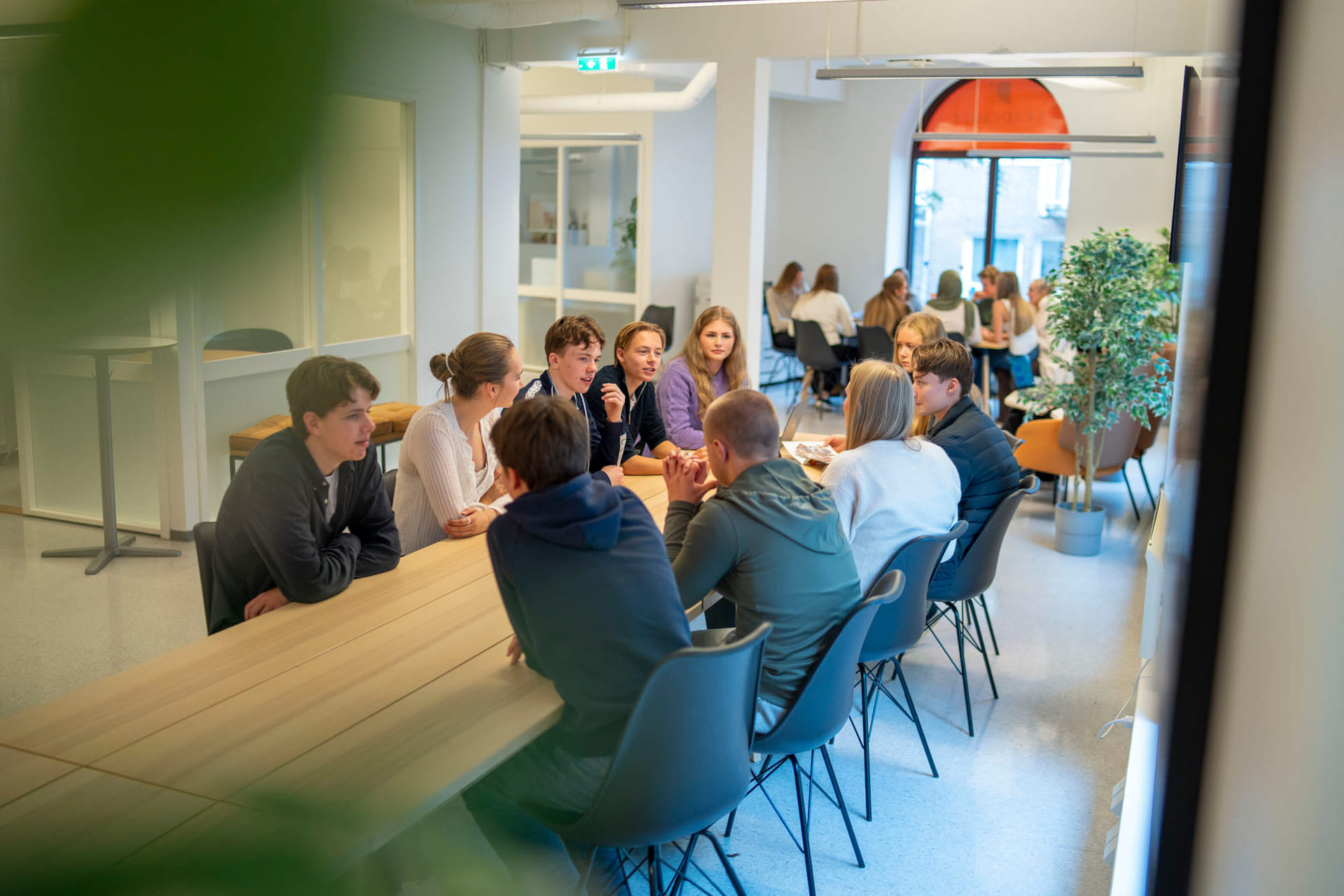 Elever prater sammen rundt et bord på Akademiet VGS Bergen