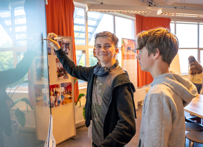 Elever jobber sammen med tavle i klasserommet