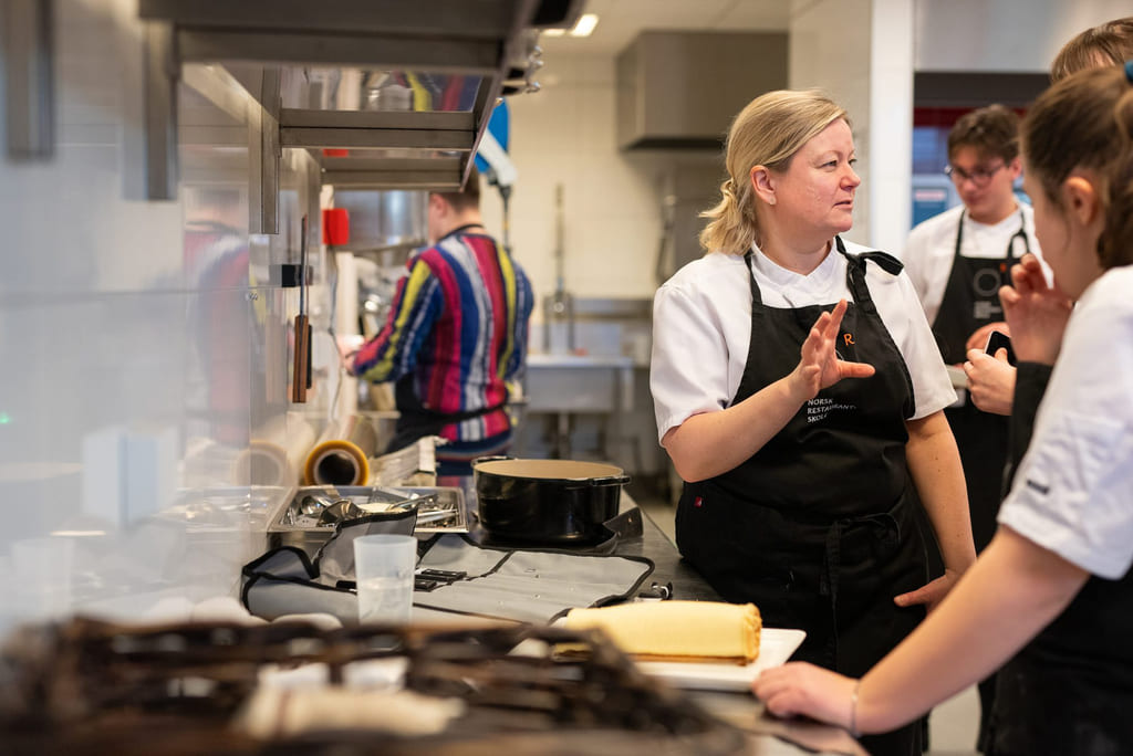 Lærer instruerer på kjøkkenet på Akademiet norsk restaurantskole