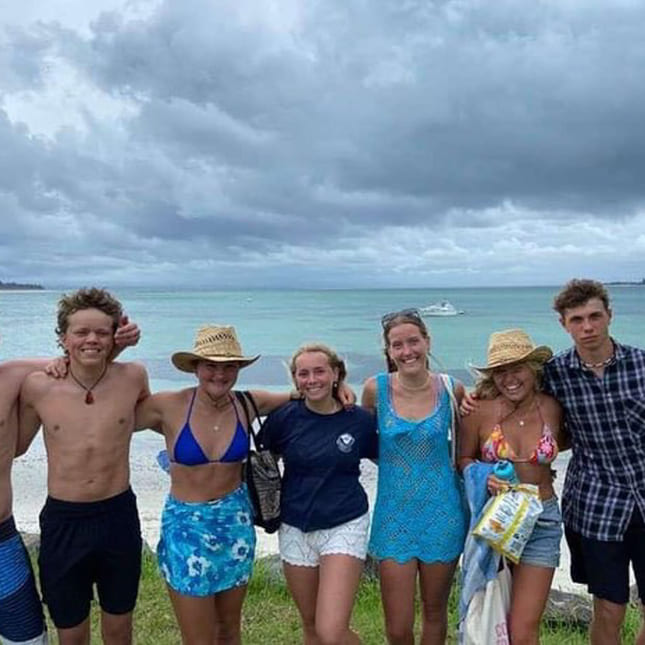 Utvekslingselever står ved siden av hverandre på en strand i New Zealand.