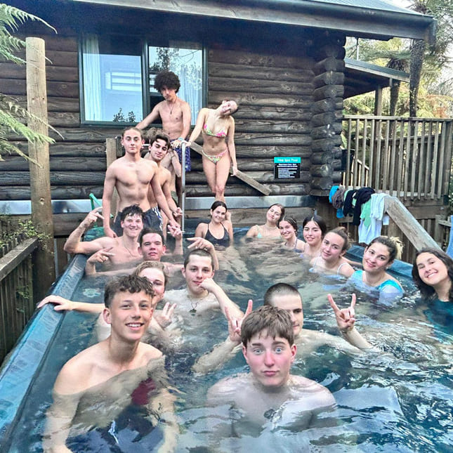 en gjeng ungdommer sitter i en jacuzzi i new zealand