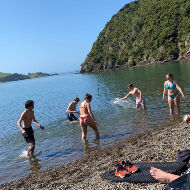 oliver og venner på en strand i new zealand.