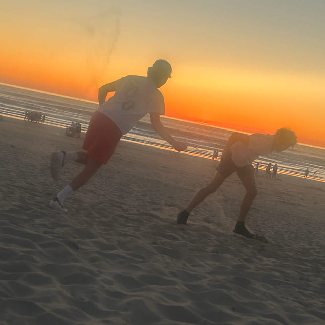 To gutter løper på stranda i USA.