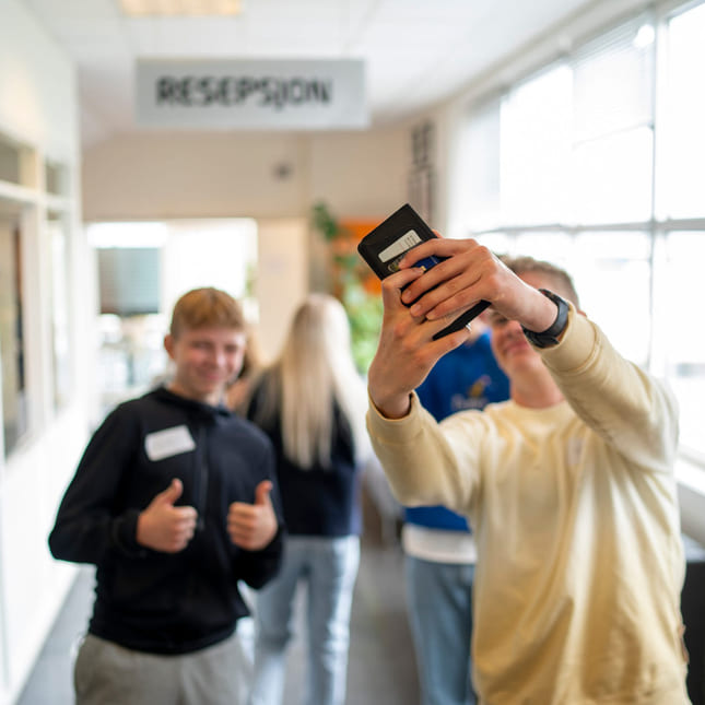 Elev tar en selfie i gangen på Akademiet VGS Ålesund