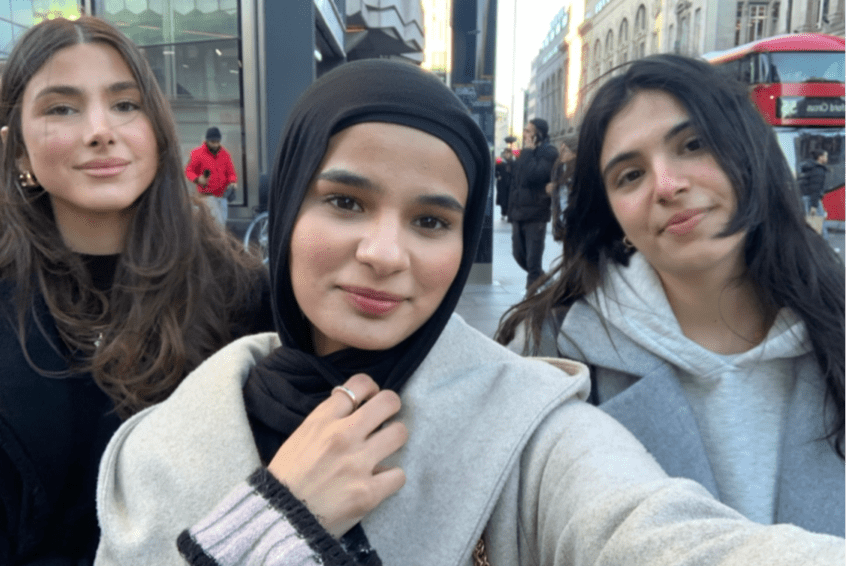 Tre elever tar en selfie i London.