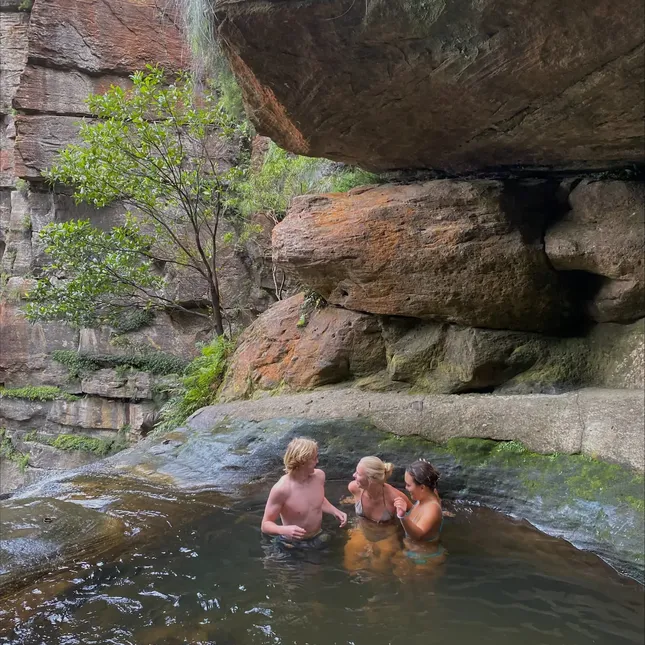 tre personer bader i en kulp i Australia