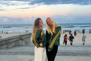 Emma og en venninne poserer på promenaden ved stranda