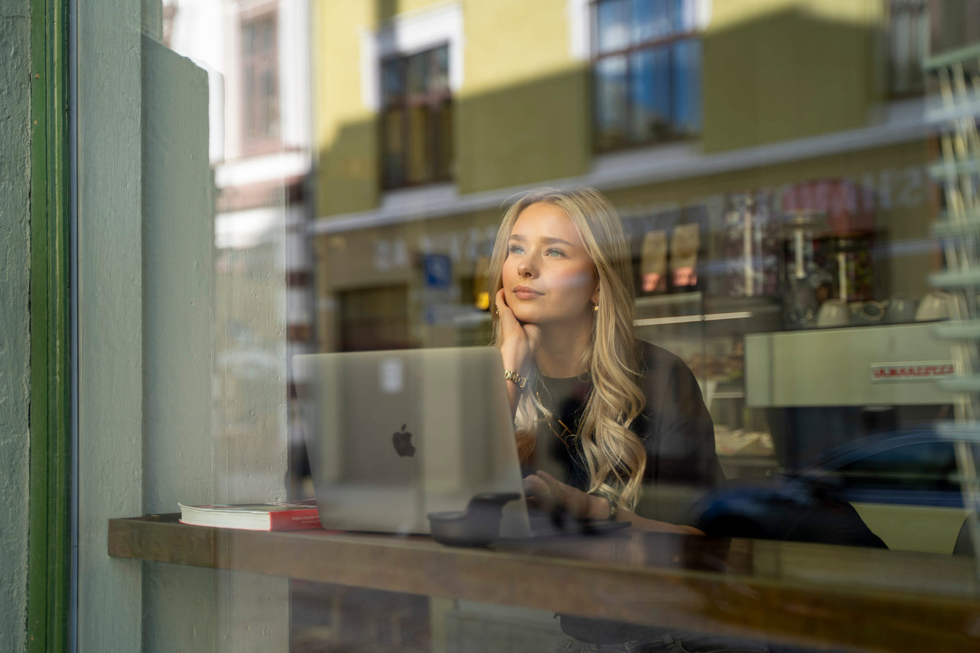 Elev sitter på en kafé med macbook for å studere