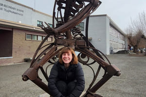 Johanna poserer foran skolens maskot og statue.