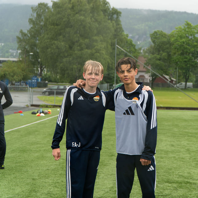 To elever smiler på fotballtrening med Strømsgodset