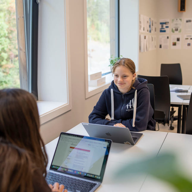 To elever snakker sammen i studietid på Akademiet Ungdomsskole Asker