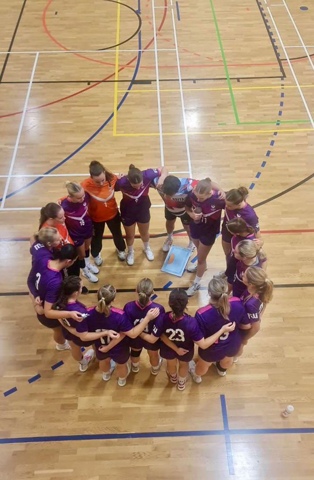 Guro med håndballaget i en ring på banen i Loughborough