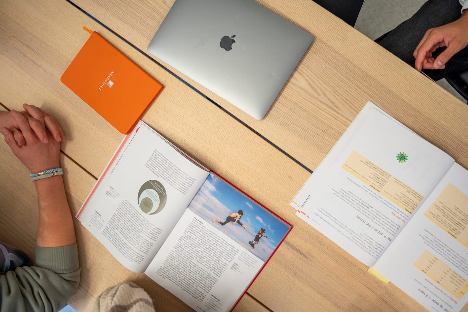 Mac og bøker på bord.