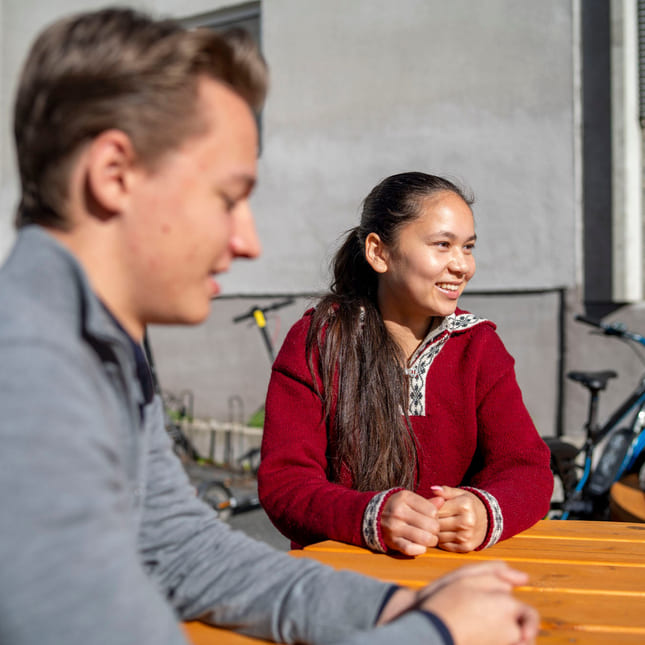 Elever sitter utenfor Akademiet VGS Kongsberg