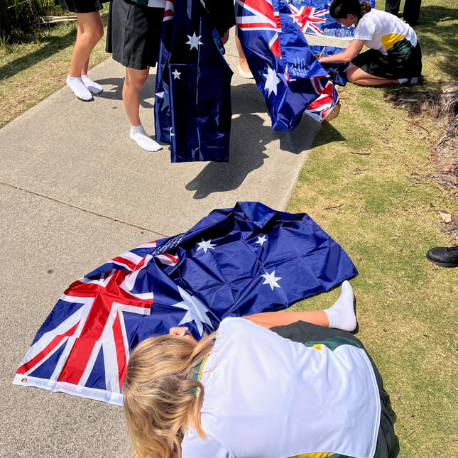 En gjeng elever skriver på det australske flagget for graduation