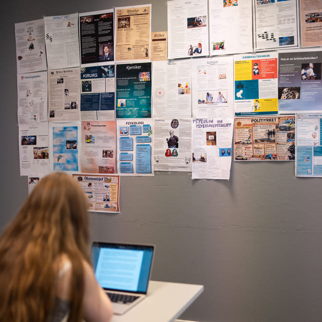 Elev som sitter foran veggaviser i Ålesund