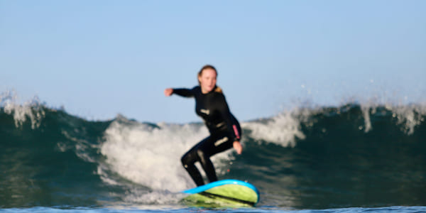 Anna surfer i New Zealand