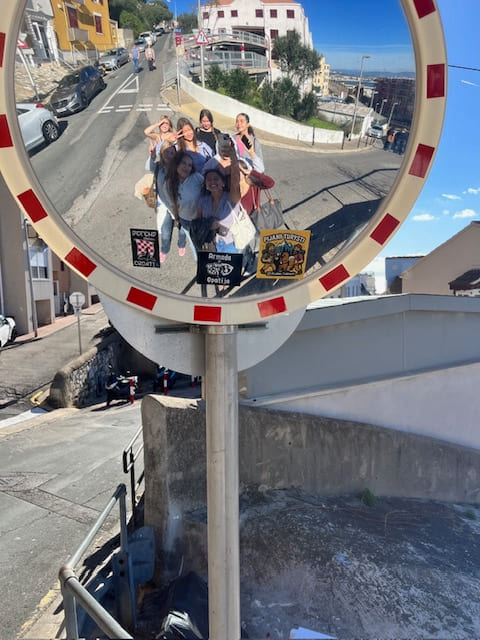Maria med venner tar selfie i et gateskilt i Cadiz